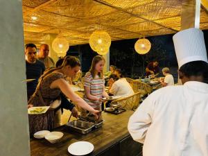 a group of people preparing food in a restaurant at 88th - ELLA in Ella