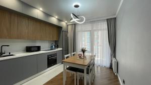 a kitchen with a table and a dining room at 2х комнатные апартаменты 4-177 in Almaty