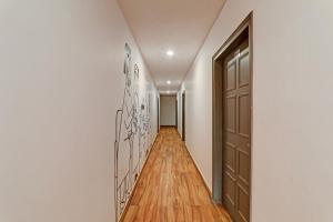 a hallway with a door and a wooden floor at Townhouse 386 The Shubham in Bijnaur