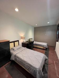 a bedroom with two beds and a desk and a bed at SOETJIPTO HOME STAY VILLA in Jakarta
