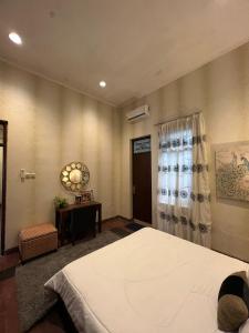 a bedroom with a bed and a table and a window at SOETJIPTO HOME STAY VILLA in Jakarta