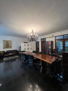 uma sala de jantar com uma grande mesa de madeira e cadeiras em SOETJIPTO HOME STAY VILLA em Jakarta