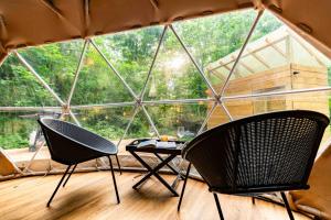 two chairs and a table in a room with a large window at Solace glamping in Sevierville