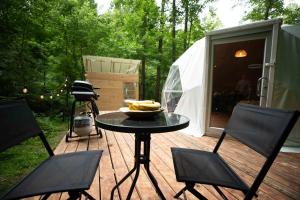 a table and chairs on a wooden deck with a tent at Solace glamping in Sevierville