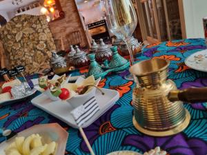 - une table avec une assiette de nourriture et un verre de vin dans l'établissement Breizh & Breakfast, à Rosporden