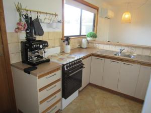 a kitchen with a stove and a sink at Quandong Beach Shack in Port Moorowie