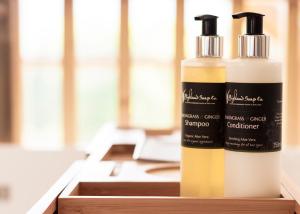 two bottles of hair products sitting on a wooden shelf at Wild Nurture Eco Luxury Offgrid Log Cabin in Fort William