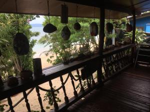 a balcony with a view of a beach with plants at Bangpo Village Tiny Country Beach House in Koh Samui 