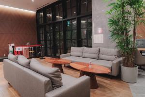 a living room with couches and tables and plants at Travelodge Honmachi Osaka in Osaka