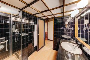 baño con paredes de azulejos negros y lavabo en Cinnamon Citadel Kandy, en Kandy
