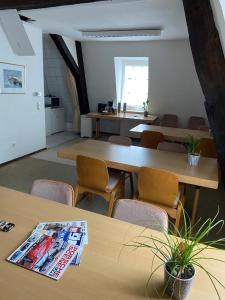 una habitación con mesas y sillas y una revista en la mesa en Nringrooms Hostel Adenau, en Adenau