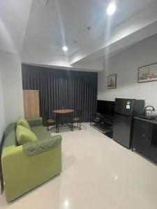 a living room with a green couch and a table at Luxe 1-Bedroom Haven with Ocean View on the 5th Floor of Kalani Tower in Nongsa