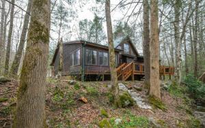 a log cabin in the woods with trees at Shady Creek in Gatlinburg