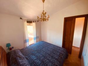 a bedroom with a bed and a chandelier at MEDUSA apartment Baja Sardinia in Cala Bitta
