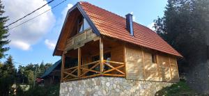 une cabine avec un toit rouge au-dessus d'un bâtiment dans l'établissement Brvnara Tarska Zora, à Sekulić 