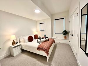 - une chambre blanche avec un lit et une fenêtre dans l'établissement Stylish, Glamorous & Serene 6BR Villa, Near Vancouver, Oasis for Groups and Large Families, à Langley