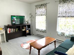 uma sala de estar com um sofá e uma televisão em Summer Breeze em Sooke