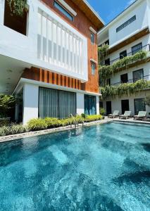 a swimming pool in front of a building at Hoianese Hotel - Lip Lip Pool Villa in Hoi An