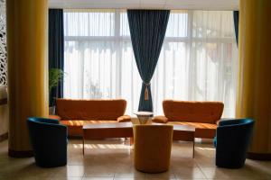 uma sala de estar com duas cadeiras laranja e uma mesa em Complex Balnear Covasna em Covasna