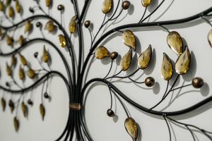 a metal plant with gold leaves on a wall at CommonSide Luxury in Mitcham