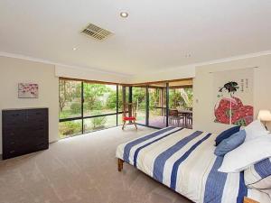 a bedroom with a bed and a large window at Sky Blue Retreat in North Boyanup