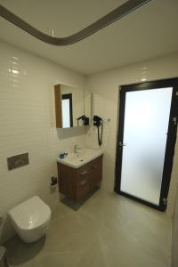 a bathroom with a toilet and a sink and a mirror at Tut Hotel in Antalya