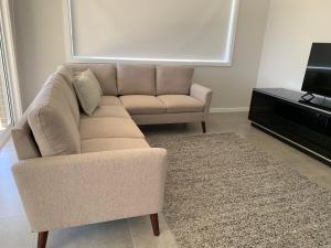 a living room with a couch and a television at 21 On Court in Mudgee