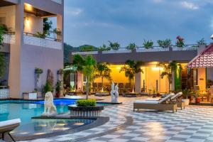 a hotel courtyard with a pool and statues at Mountain Creek Villa Udaipur in Udaipur