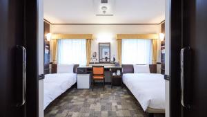 Pokój hotelowy z 2 łóżkami i biurkiem w obiekcie Toyoko Inn Saitama Iwatsuki Ekimae w mieście Saitama