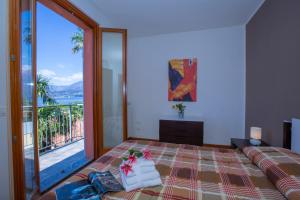 a bedroom with a bed and a large glass window at Fontana Del Lago Apartments in Varenna