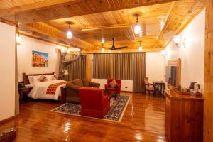 a bedroom with a bed and a couch and chair at Chillaru Spa & Resort in Kasauli