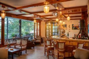a dining room with a bar and tables and chairs at Chillaru Spa & Resort in Kasauli