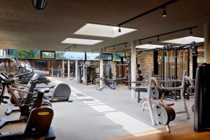 einen Fitnessraum mit vielen Laufbändern und Maschinen in der Unterkunft Hotel Quelle Nature Spa Resort in Santa Maddalena in Casies