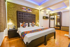 ein Schlafzimmer mit einem großen Bett in einem Zimmer in der Unterkunft FabEscape Sion Resort With Pool, Candolim in Candolim