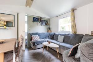 萊格卡弗爾雷的住宿－Mobilhome 6-8 personnes Cap Ferret，客厅配有蓝色的沙发和桌子