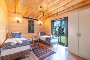 a bedroom with two beds in a log cabin at Aronia Bungalow in Elmalık