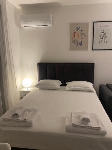 a bedroom with a white bed with towels on it at Apartman PORTO in Trebinje +53 photos