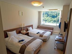 um quarto de hotel com duas camas e uma janela em 真田昌幸-幸村父子の隠れ宿 紀伊見荘 em Hashimoto