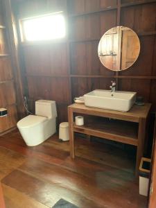 W łazience znajduje się toaleta, umywalka i lustro. w obiekcie Amaze at Themyth w mieście Mae Rim