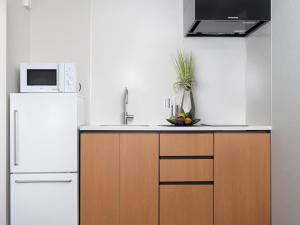 a kitchen with a white refrigerator and a microwave at MIMARU KYOTO KAWARAMACHI GOJO in Kyoto