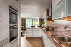 a kitchen with white cabinets and stainless steel appliances at Meerberg in Pertisau