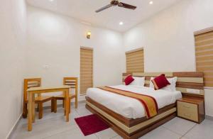a bedroom with a bed with a table and a tableasonable at Greenfield Homestay in Vythiri
