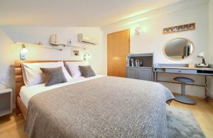 una camera con letto, scrivania e specchio di Sea & Wine Apartment with Terrace & Scenic Sea View, Punat a Punat