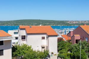 un gruppo di edifici con tetti arancioni in una città di Sea & Wine Apartment with Terrace & Scenic Sea View, Punat a Punat