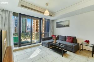 a living room with a couch and a large window at bnbmehomes - Cozy modern JLT flat next to metro - 405 in Dubai