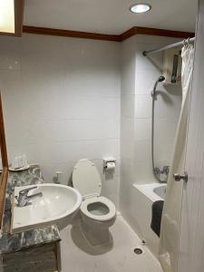 a bathroom with a toilet and a sink at Imperial Sakon Hotel in Sakon Nakhon