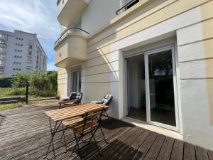a wooden deck with a table and chairs on a building at La terrasse des Thermes, Jura in Lons-le-Saunier