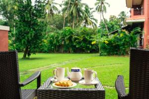 une table avec des tasses et des assiettes de nourriture dans l'établissement Jasminn Hotel - AM Hotel Kollection, à Betalbatim