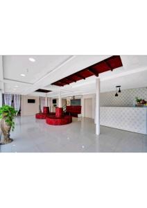 sala de estar con sillas rojas y techo en Gods County Hotels & Resorts, en Tarapith