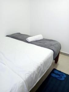 a white bed with a towel on top of it at Amalya suites by TJ3 in Eldoret